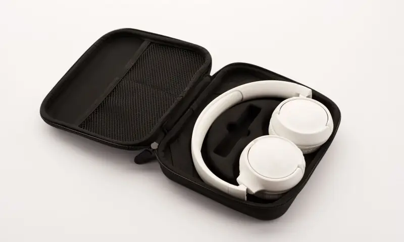 Audífonos blancos guardados en un estuche de viaje